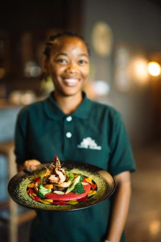 a woman is holding a plate of food at Clove Island Essence & Spa Boutique in Matemwe