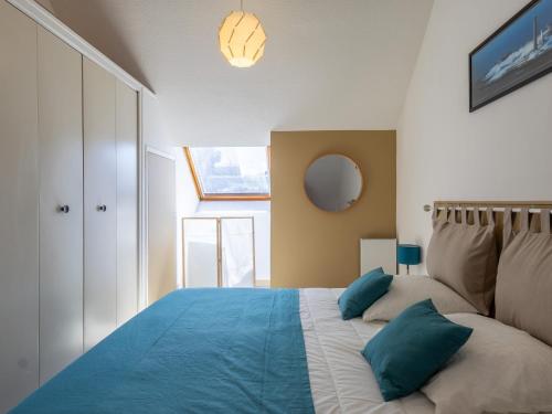 a bedroom with a large bed with blue pillows at Ty Fox by Madame est Servie in Perros-Guirec