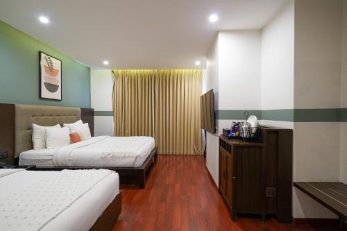 a hotel room with two beds and a television at Olive Hotel MG Road Dunsvirk Inn by Embassy Group in Bengaluru