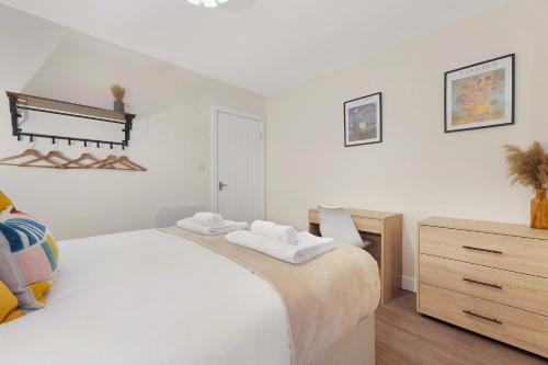 a white bedroom with a large bed and a dresser at Flat2 2BR in Horsemarket in Barnard Castle