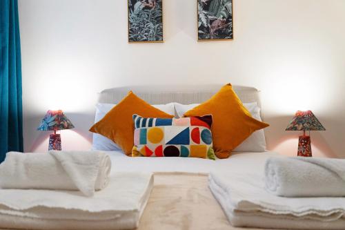 a white bed with colorful pillows on it at Flat2 2BR in Horsemarket in Barnard Castle