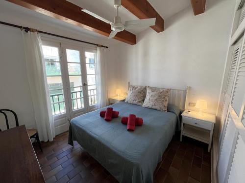 Un dormitorio con una cama con arcos rojos. en Es CASTELL 2 7 by SOM Menorca, en Fornells