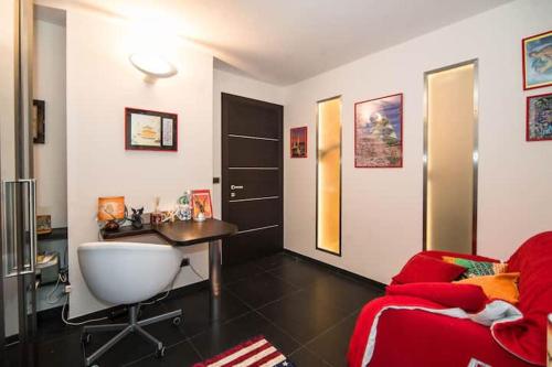 a living room with a desk and a red couch at Appartamento Bardonecchia in Bardonecchia