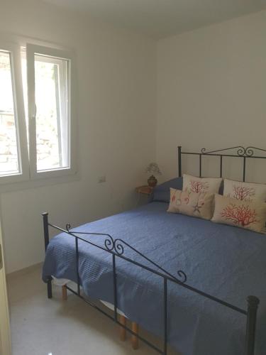 a bedroom with a bed with blue sheets and pillows at Casa Ponente in Sanremo