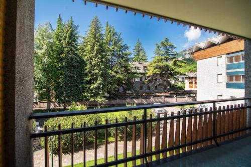 a balcony with a view of a park and trees at Appartamento Bardonecchia in Bardonecchia
