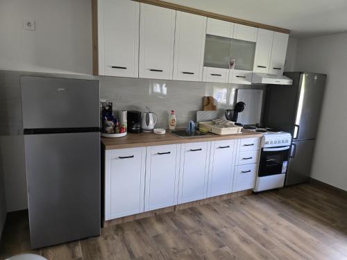 a kitchen with white cabinets and stainless steel appliances at Bed & Rest Kulina in Prigorje Brdovečko