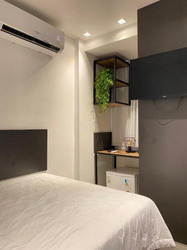 a bedroom with a bed and a plant on a shelf at Wanderlust Hostel in Maceió