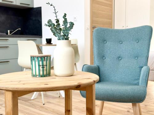 una mesa con una silla azul y un jarrón en ella en La Scène de Molière - Neuf - Clim - Central - Fibre, en Mont-de-Marsan