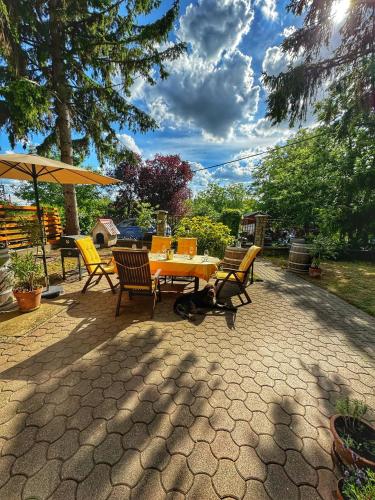 a patio with a table and chairs and an umbrella at Kamocsay Vendégház in Mór