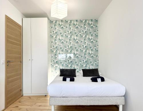 1 dormitorio con cama blanca y pared en La Scène de Molière - Neuf - Clim - Central - Fibre, en Mont-de-Marsan