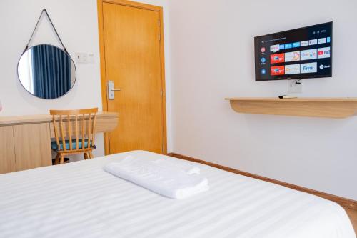 a bedroom with a bed and a tv on the wall at Turi Staypoint in Quang Ngai