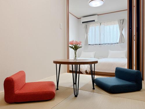 a room with a table and two chairs and a bed at Tsukisucho, 4 bedrooms, 1 Japanese style room, 4LDK, Namba, Nihonbashi, Tsutenkaku house, free parking, elevator in Osaka