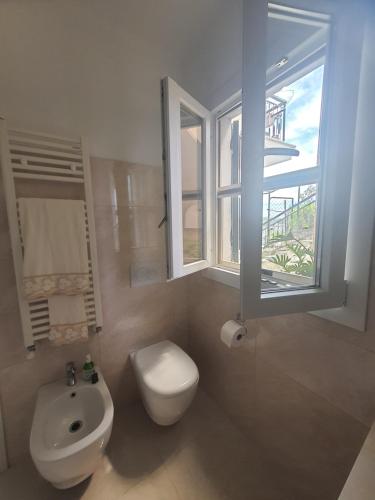 a bathroom with a toilet and a sink and a window at Casa Ponente in Sanremo