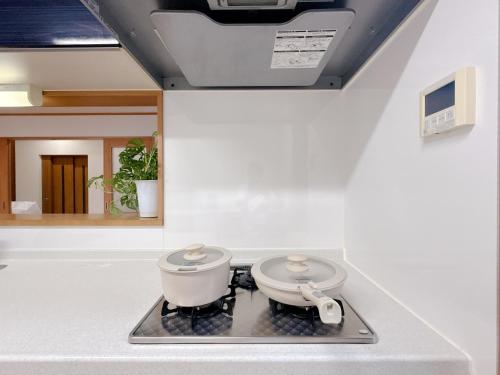 a pot on a stove in a kitchen at Tsukisucho, 4 bedrooms, 1 Japanese style room, 4LDK, Namba, Nihonbashi, Tsutenkaku house, free parking, elevator in Osaka