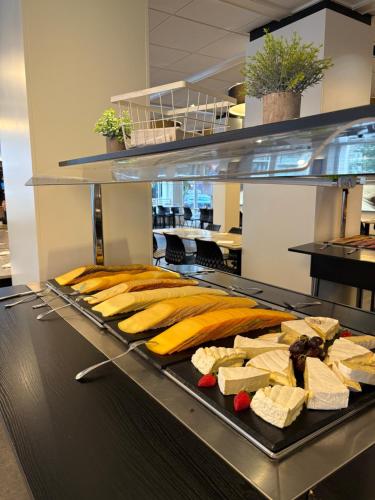 a tray of cheese and other foods on a counter at Hotel Sandeshoved Zeedijk in Nieuwpoort