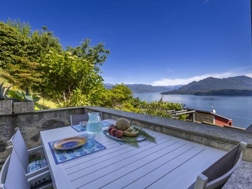 una mesa con un plato de comida en la parte superior de un balcón en Apartment Il Gianlupo Azzurro by Interhome, en Belgirate
