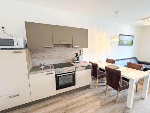 a kitchen with a stove and a table with chairs at Apartment Mentenwirt Alp Lungau by Interhome in Sankt Michael im Lungau