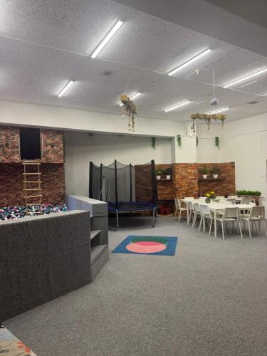 a room with a table and chairs and a stage at WooW kids club in Rīga