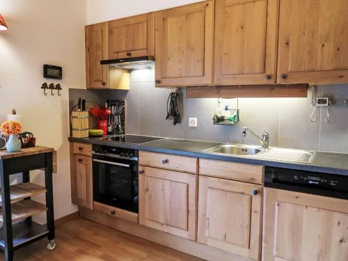 a kitchen with wooden cabinets and a sink at Apartment Mon Abri by Interhome in Les Diablerets