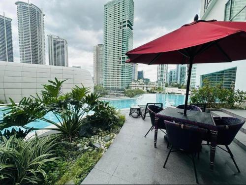 a patio with a table and chairs and an umbrella at Novotel Hotel Residences Manila by AMORE Suites in Manila