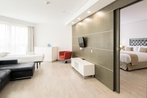 a hotel room with two beds and a tv at Cullera Holiday in Cullera