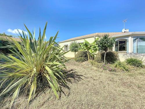 a house with a palm tree in front of it at Holiday Home Villa Sel et Pins by Interhome in Tharon-Plage
