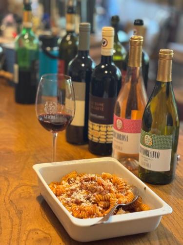 a bowl of pasta next to a glass of wine at Agriturismo Borgo dei Ricci in Impruneta