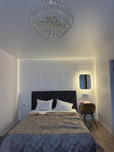 a bedroom with a large bed and a chandelier at Chornomorsk Apartment in Chornomorsk