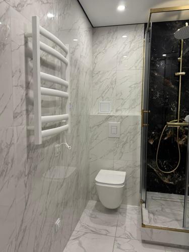 a bathroom with a toilet and a glass shower at Chornomorsk Apartment in Chornomorsk