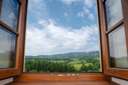 a window with a view of the hills and trees at Hotel Pohoda in Staré Město