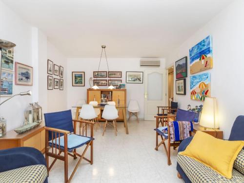 a living room with blue chairs and a table at Apartment Mar d'Aro by Interhome in Platja  d'Aro