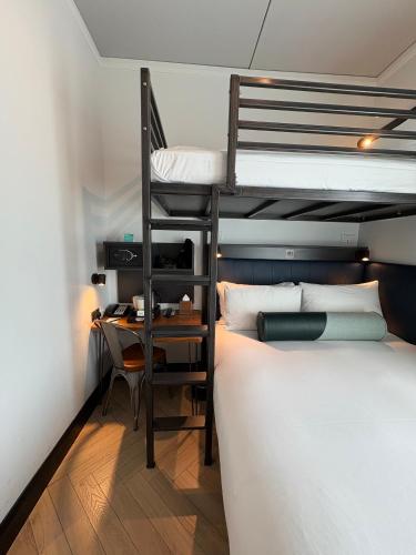 a bedroom with a bunk bed with a desk and a bunk bed at The Hendrick Smithfield in Dublin