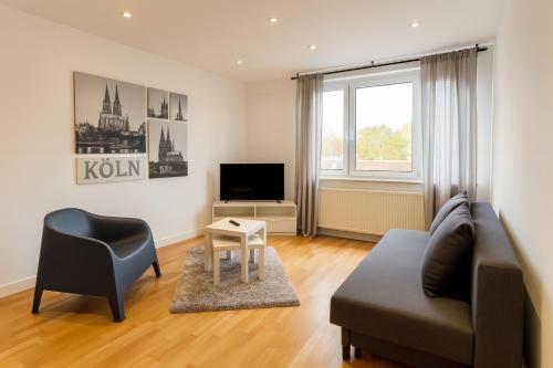 a living room with a couch and a chair and a television at Köln Frechen 44 in Frechen