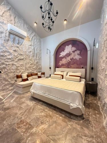 a bedroom with a large bed in a stone wall at Çınar Suit House in Akcay