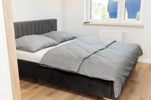 un lit avec deux oreillers dessus dans une chambre dans l'établissement Apartament Komfort, à Uniejów
