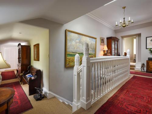 a living room with a staircase and a painting on the wall at Holiday Home Glenquiech House by Interhome in Angus