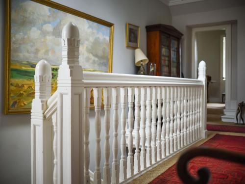 a white staircase in a house with a painting at Holiday Home Glenquiech House by Interhome in Angus