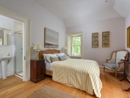 a bedroom with a bed and a sink in it at Holiday Home Glenquiech House by Interhome in Angus