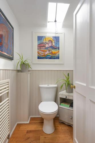 a bathroom with a toilet and a painting on the wall at Holiday Home Glenquiech House by Interhome in Angus