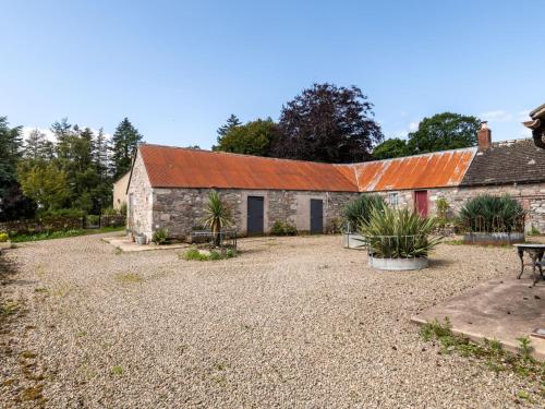 an old stone building with an orange roof at Holiday Home Glenquiech House by Interhome in Angus