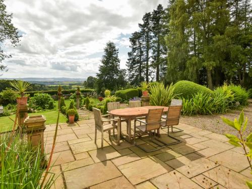 a patio with a table and chairs in a garden at Holiday Home Glenquiech House by Interhome in Angus