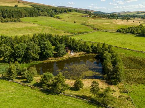 an aerial view of a field with a pond at Holiday Home Glenquiech House by Interhome in Angus