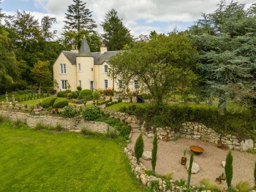 an estate with a stone wall and a house at Holiday Home Glenquiech House by Interhome in Angus