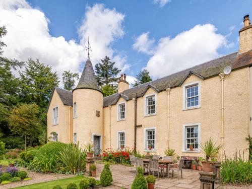 an exterior view of a house with a turret at Holiday Home Glenquiech House by Interhome in Angus