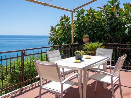 a white table and chairs on a balcony with the ocean at Apartment La Terrazza by Interhome in Cipressa