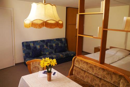 a living room with a couch and a table with yellow flowers at Ferienwohnung Pferdestall in Reinhardtsdorf