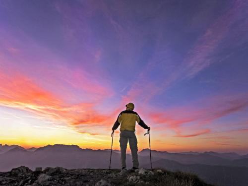 a man standing on top of a mountain watching the sunset at Apartment Angelika by Interhome in Brixlegg