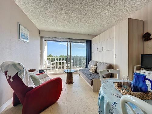 a living room with a couch and a tv at Studio Mer & Soleil-3 by Interhome in Saint-Brévin-lʼOcéan