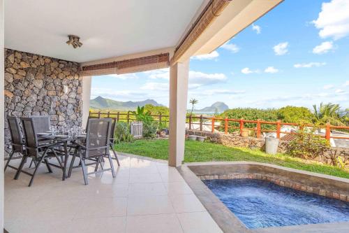 リヴィエール・ノワールにあるNumi Bay - Amazing Apartment with Morne Viewのパティオ(テーブル、椅子付)、スイミングプールが備わります。
