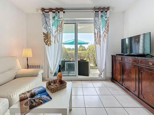 ein Wohnzimmer mit Sofa und Fernseher in der Unterkunft Apartment L'Orée du Golf-3 by Interhome in Pornic